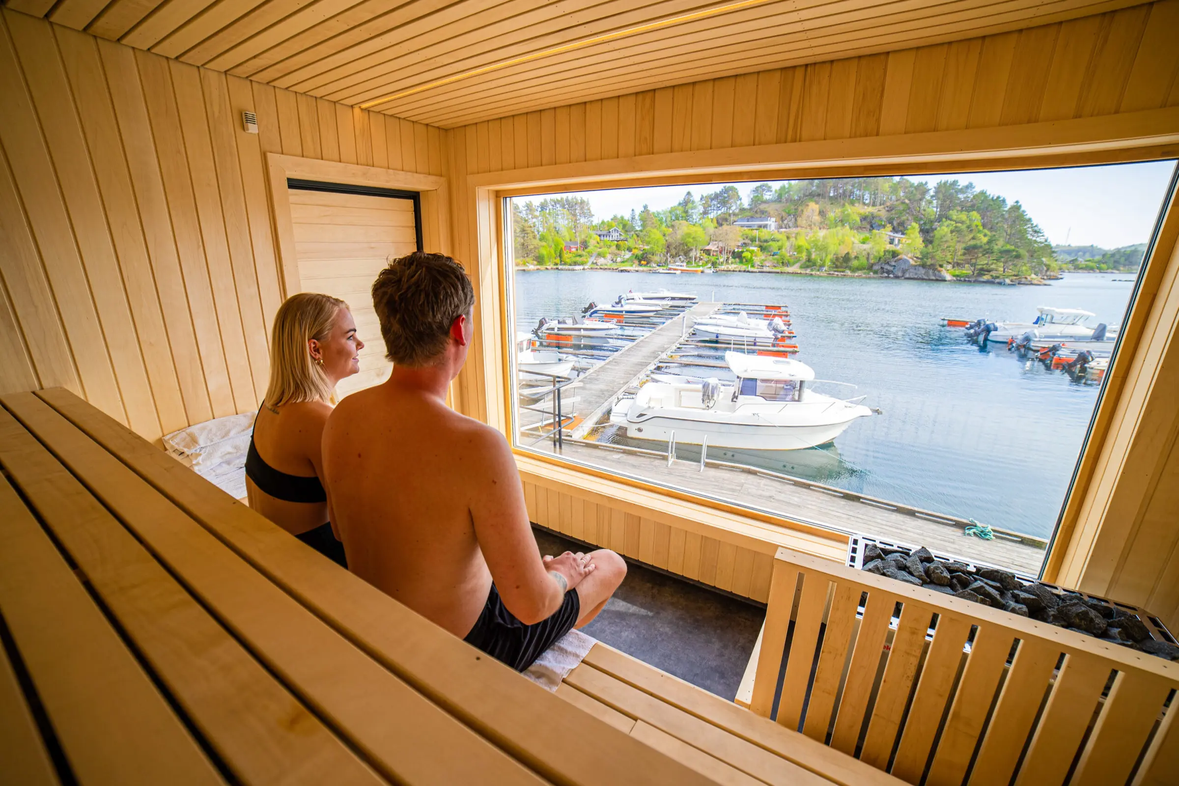 To gjester i Tregde Sauna med panoramavindu mot havna